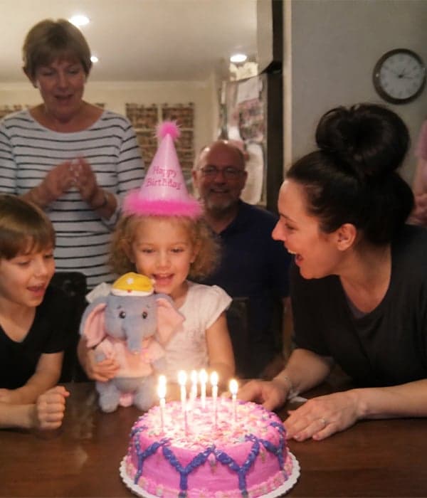 Custom blue elephant plush toy with party hat at a family birthday celebration with cake and candles